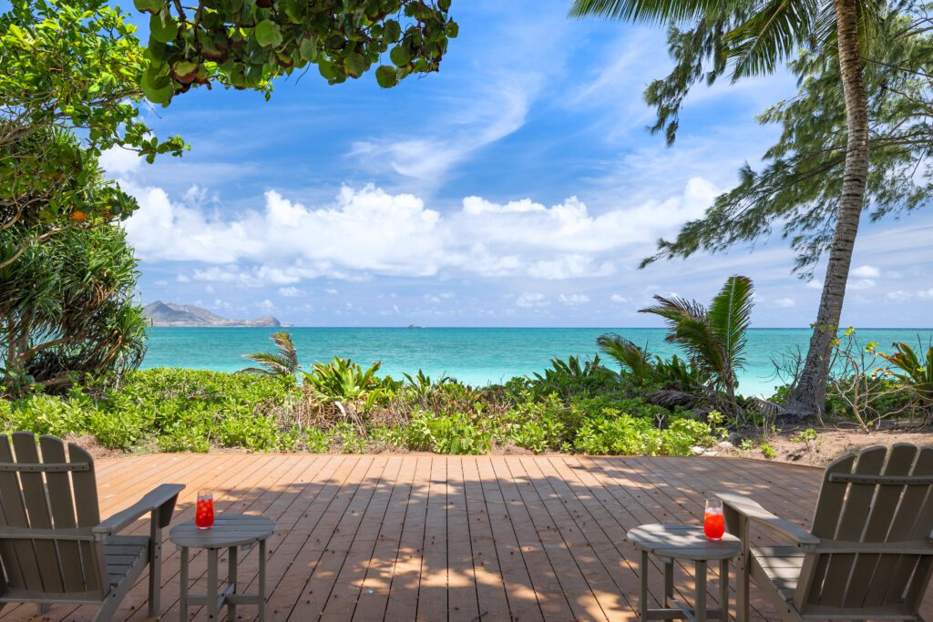 Oceanfront deck with Adirondack chairs facing turquoise Kailua Bay at Kailuana Beachfront Estate