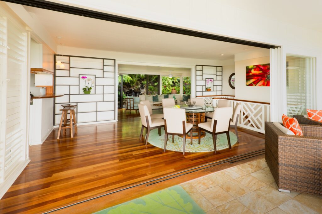 Living area flowing into the dining room over koa floors at Kehaulani Ridge