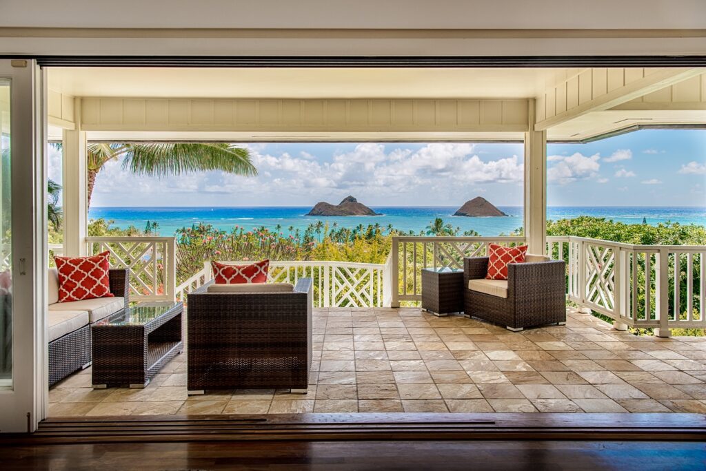 Living room opening fully to the lanai and the Mokulua Islands at Kehaulani Ridge