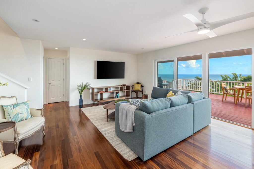 Living room opening to the ocean-view lanai at Koohoo Place