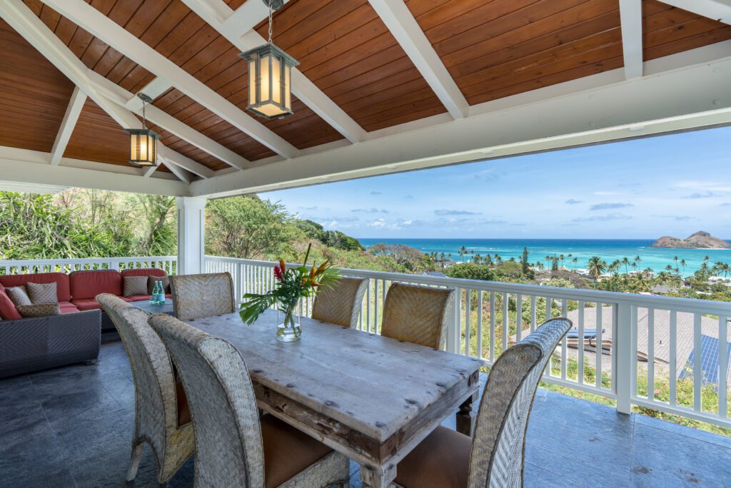 Lanai dining table with ocean and island views at Makani Moana