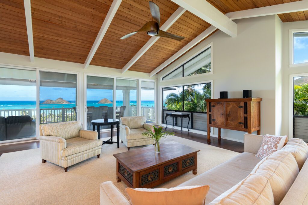 Living room with walls of glass facing the ocean at Makani Moana