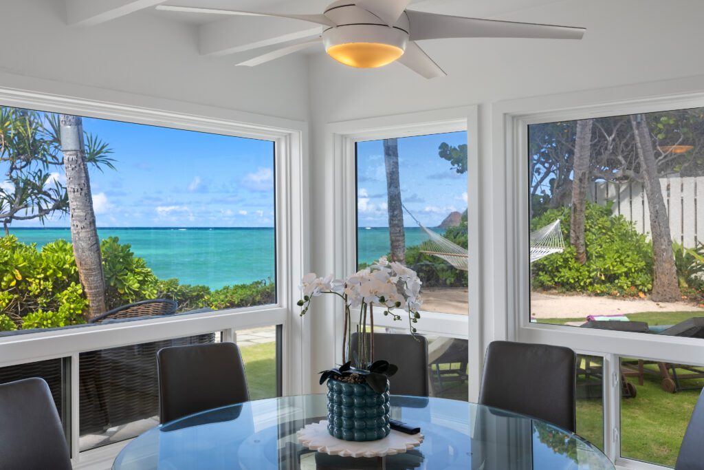 Breakfast table with ocean views through walls of windows at Moku Nui