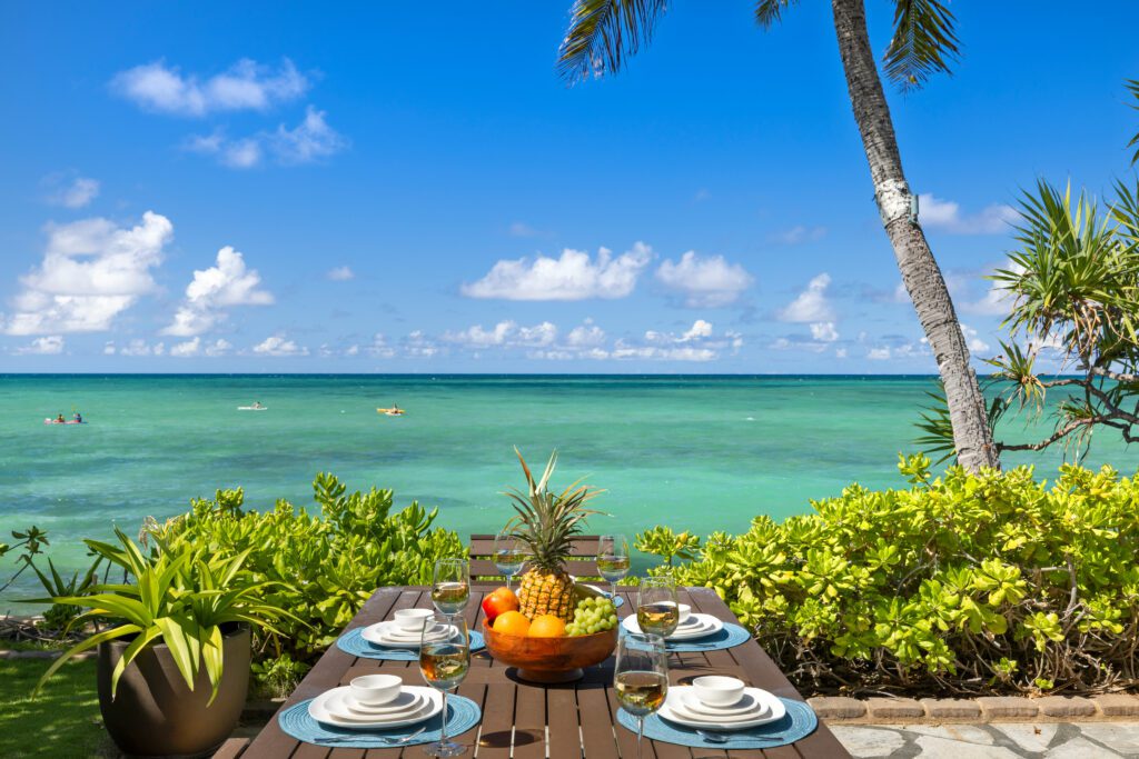 Oceanfront table set for breakfast above the turquoise water at Moku Nui