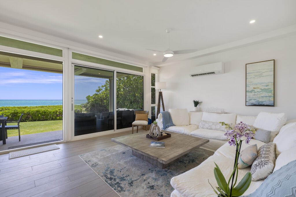 Living room with white sectional sofa and sliding doors to the lanai at Pueohala